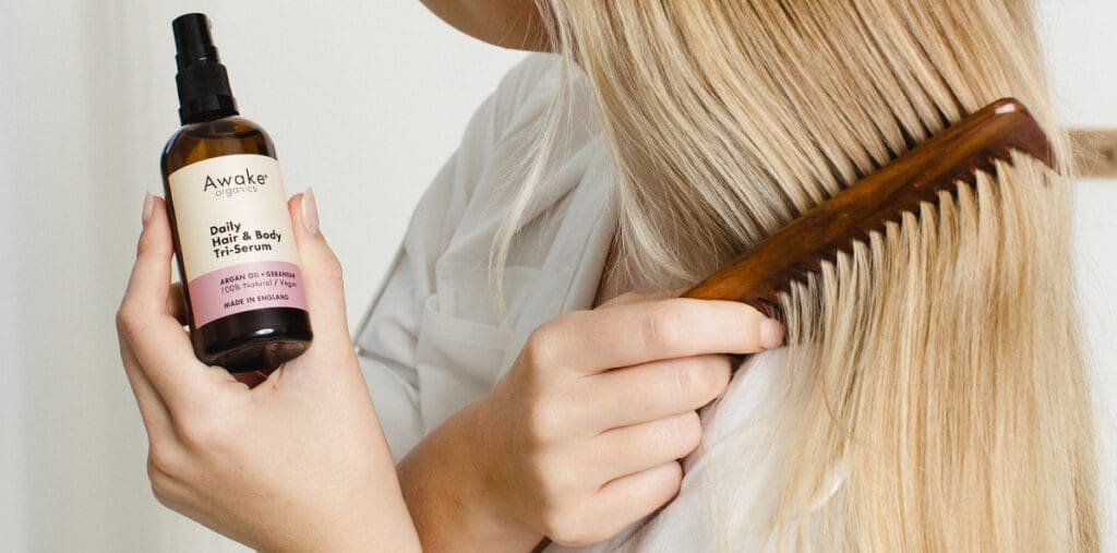Woman putting oil treatment on hair.
